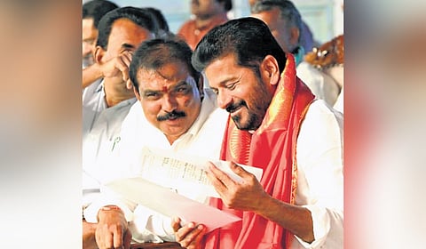 Chief Minister A Revanth Reddy is all smiles as he converses with BJP MLA Payal Shankar during a public meeting at Adilabad on Thursday